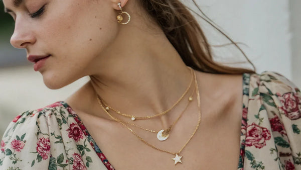 Young woman wearing delicate yellow gold jewelry.