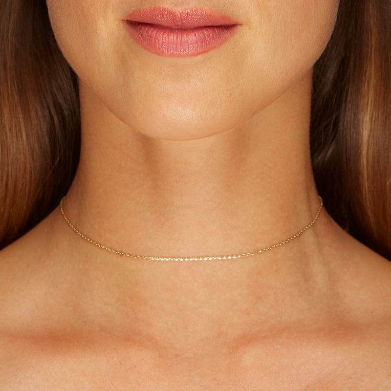 This fine 14 karat gold necklace is the ultimate statement of minimalism. It is the perfect gold necklace for women who love to layer jewels.   Our Basic Fine Necklace is available in two lengths. A gold choker necklace in 34 cm extendable to 37cm and a gold necklace in 39cm extendable to 42cm.