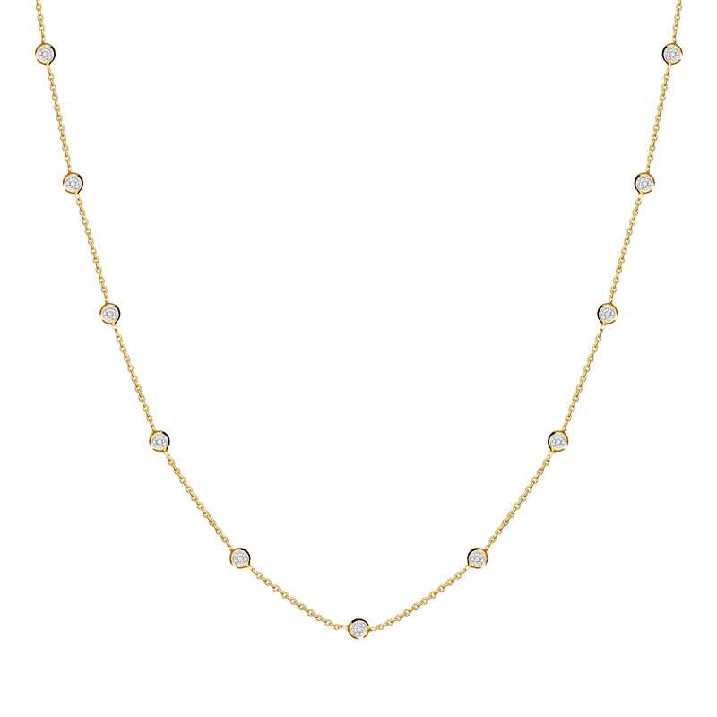 This delicate 14 karat gold necklace is handmade and features sparkling bezel - set stones. Diamond gold necklace.