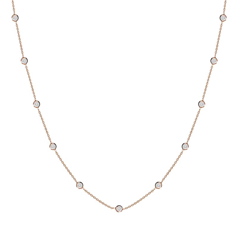 This delicate 14 karat gold necklace is handmade and features sparkling bezel - set stones. Diamond gold necklace.