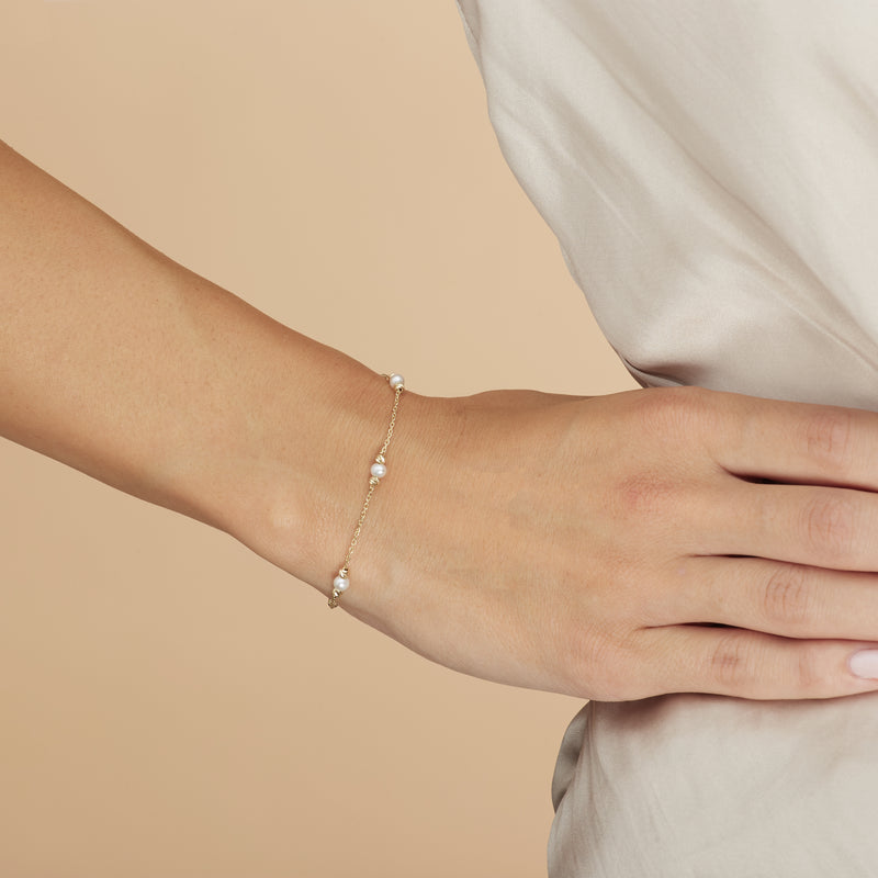 This handmade 14 karat gold pearl bracelet is an essential classic for every day. Each freshwater pearl is encased by diamond cut gold balls that reflect the light and add an extra sparkle to your wrist. 