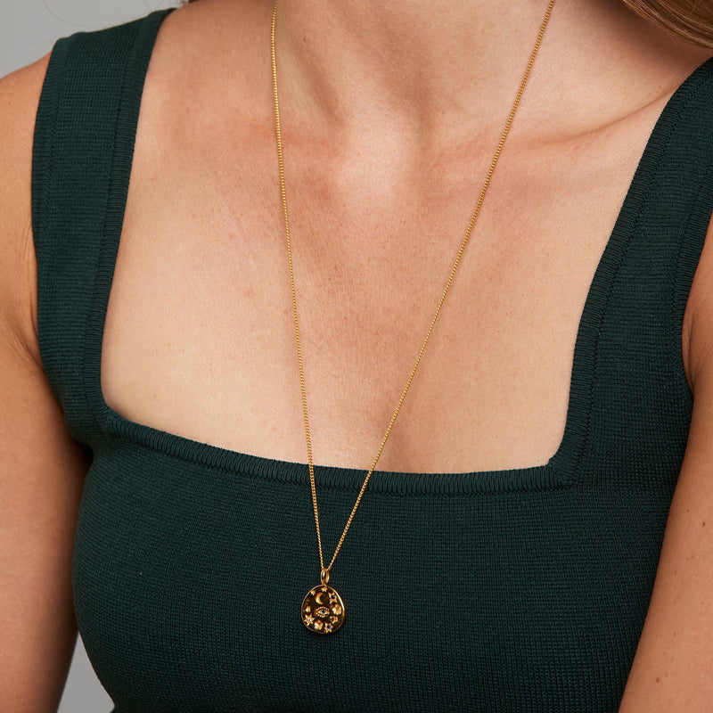 A magical and elegant gold pendant. The Magic Pendant features white and blue topaz stones set in moons, stars and evil eye protection symbols. This pendant imbues you with magic and sparkle. Team it with the matching Magic Hoop Earrings or any gold necklaces for a layering look.