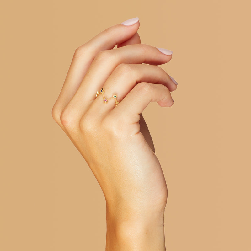 A 14 karat gold ring with handset gemstones. Our Multiple Star Ring is inspired by warm nights of star gazing. The emerald, sapphire and ruby stones add a playful glow to your hand. 