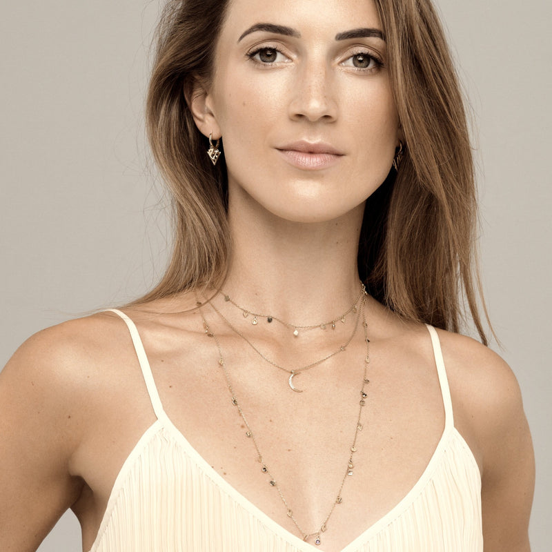 A magical 14 karat gold diamond necklace that will become your day to night companion.   This diamond pendant is inspired be the crescent moon and adorned with 9 handset sparkling diamonds.