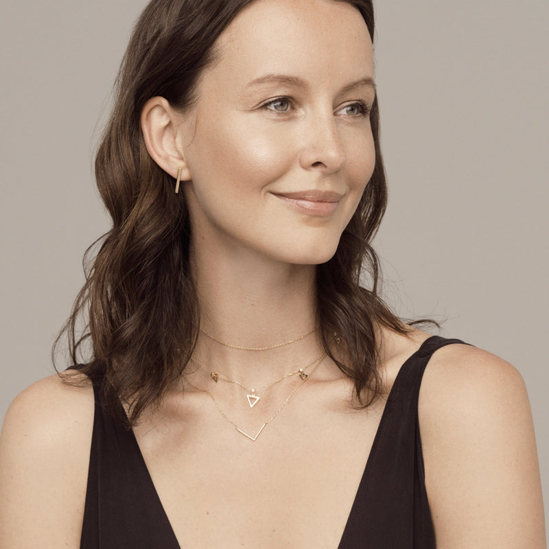 This minimalistic 14 karat gold earring is an essential piece for day to night wear.   The simple design of the bar goes perfectly as a main earring and can be combined with other ear jewels.