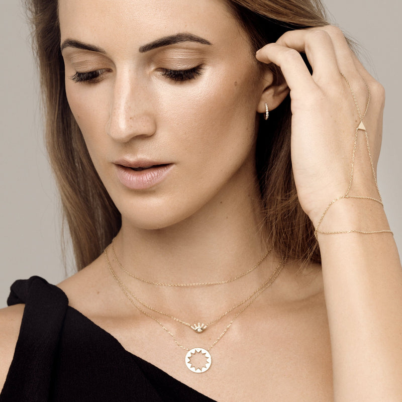 Our 14 karat gold huggie earrings feature handset diamond pave stones and are the ultimate essential for an every day sophisticated look.