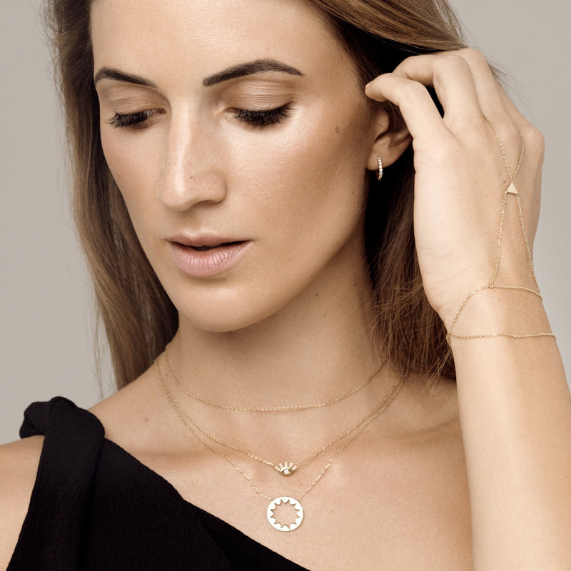 This 14 karat gold diamond pendant is inspired by mediterranean summer days and is the ultimate piece for sun-worshippers. The pendant features 4 handset sparkling diamonds pointing out the cardinal points. 