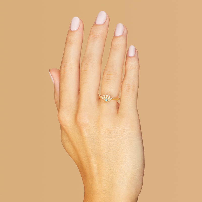 This 14 karat gold diamond ring is our dream jewelry piece. The turquoise stone in the center of the eye is encased with pave set diamond lashes. A magical gold ring that lasts a lifetime.